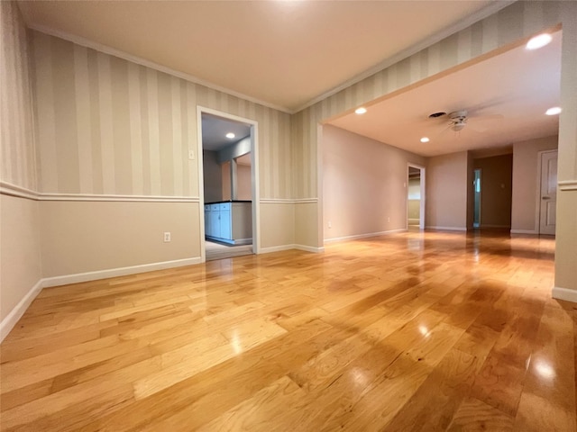 spare room with a ceiling fan, light wood-style floors, baseboards, and wallpapered walls