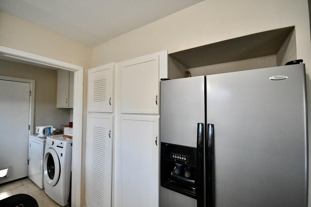 kitchen with light tile patterned flooring, white cabinetry, light countertops, independent washer and dryer, and stainless steel refrigerator with ice dispenser