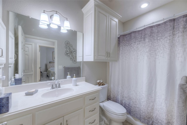 full bathroom with toilet, ensuite bath, and vanity