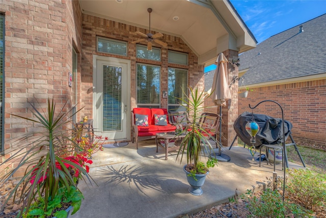 doorway to property with a patio area, roof with shingles, and brick siding