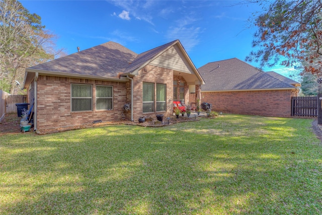 rear view of house with brick siding and a lawn