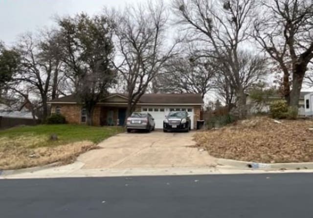 ranch-style house with an attached garage and concrete driveway