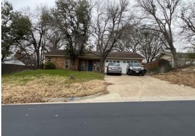 ranch-style home with concrete driveway and an attached garage