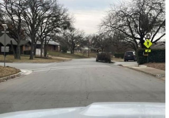 view of street with curbs, traffic signs, and sidewalks