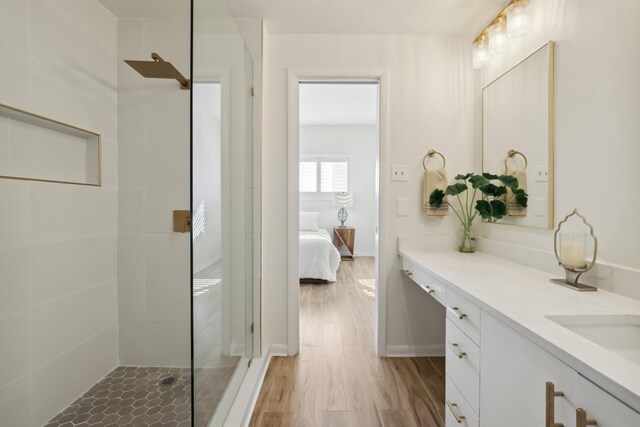 full bath featuring ensuite bath, a tile shower, wood finished floors, and vanity