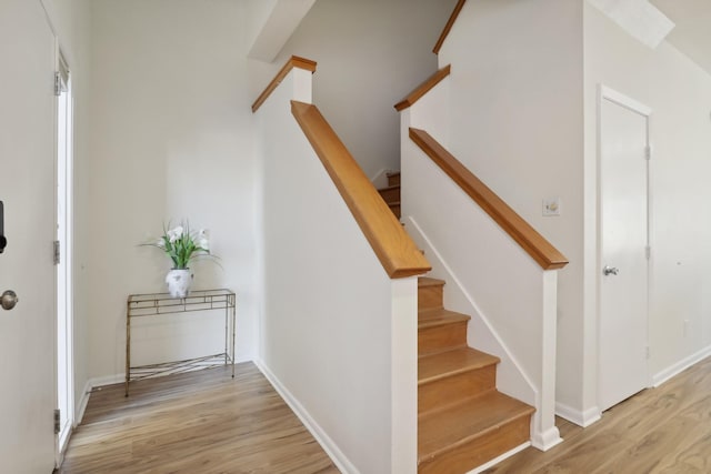 staircase with baseboards and wood finished floors