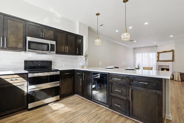 kitchen with light wood finished floors, beverage cooler, decorative backsplash, a peninsula, and stainless steel appliances