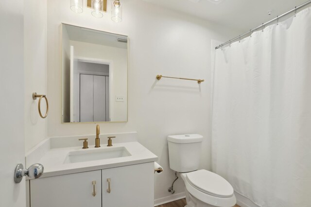 bathroom with toilet, baseboards, a shower with shower curtain, and vanity