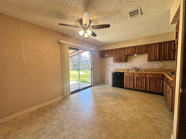 kitchen featuring black dishwasher, light floors, light countertops, visible vents, and a sink