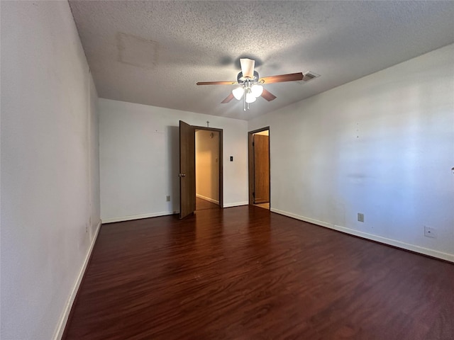 unfurnished room featuring a textured ceiling, ceiling fan, wood finished floors, visible vents, and baseboards