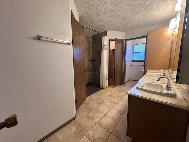 bathroom featuring a sink, a textured ceiling, a shower with shower curtain, and double vanity