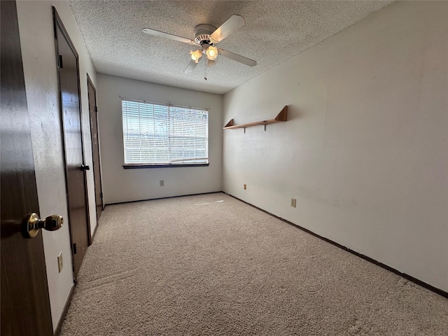 unfurnished bedroom with a ceiling fan, light carpet, a textured ceiling, and baseboards