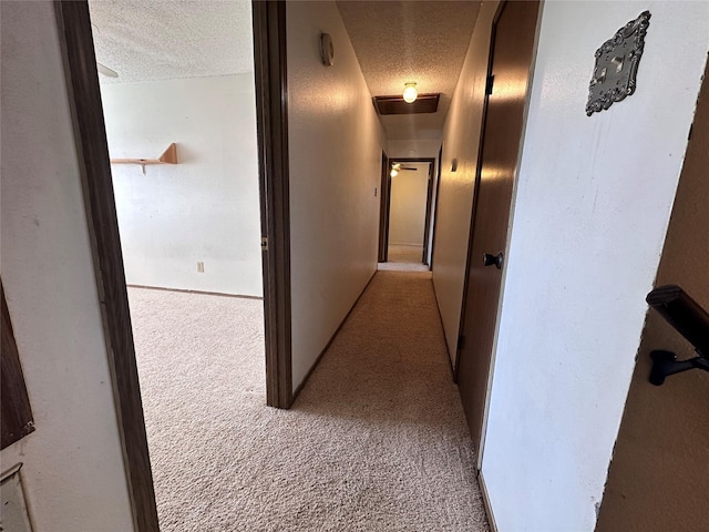 hall with a textured ceiling and carpet