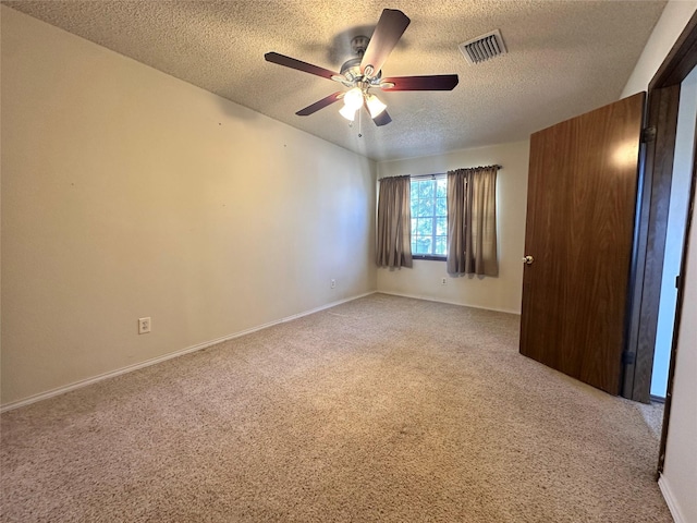 unfurnished room with light colored carpet, visible vents, ceiling fan, a textured ceiling, and baseboards