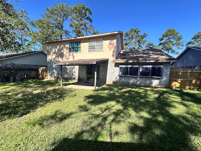 back of house with a yard, a fenced backyard, a patio, and brick siding