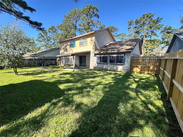 back of property with a yard, a fenced backyard, and brick siding