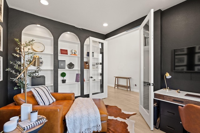 interior space with light wood-style floors, recessed lighting, built in shelves, and french doors