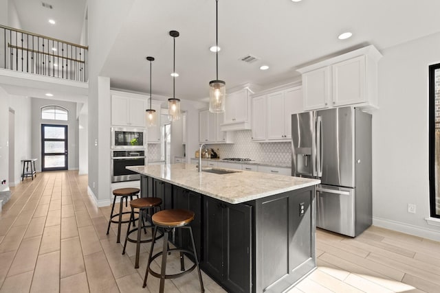 kitchen featuring white cabinetry, visible vents, appliances with stainless steel finishes, and a sink