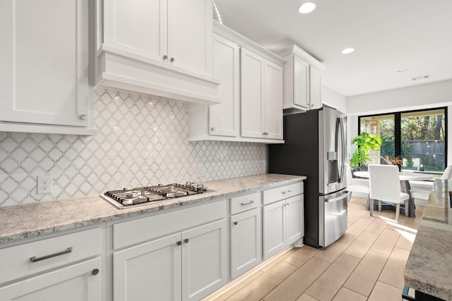 kitchen featuring recessed lighting, stainless steel appliances, visible vents, white cabinetry, and backsplash