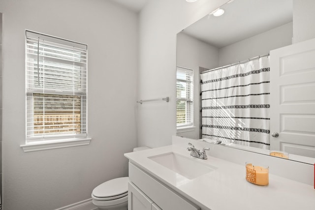 full bathroom with toilet, a shower with curtain, baseboards, and vanity