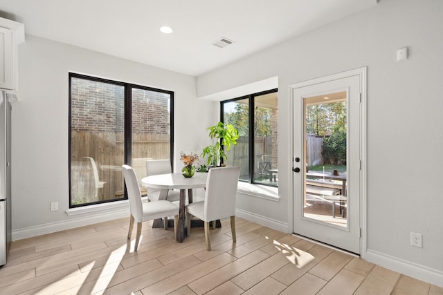 dining room with wood tiled floor, visible vents, and baseboards