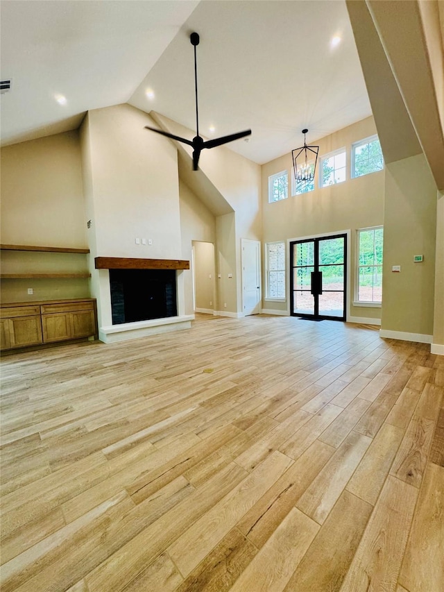 212 Rim Rock Rd, Huntsville, TX 77340 - unfurnished living room with light wood-type flooring, high vaulted ceiling, baseboards, a chandelier, and recessed lighting
