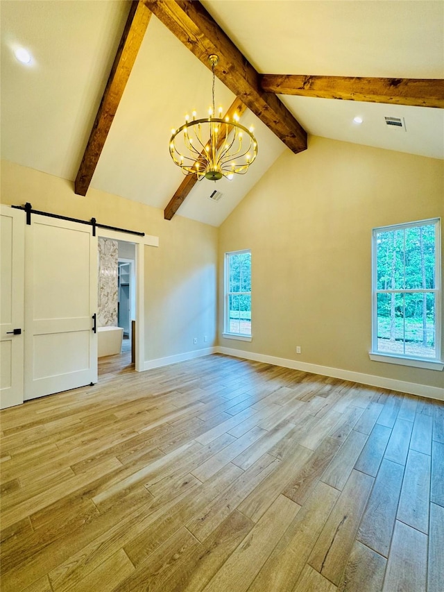 212 Rim Rock Rd, Huntsville, TX 77340 - unfurnished living room featuring a barn door, a chandelier, light wood finished floors, beamed ceiling, and baseboards