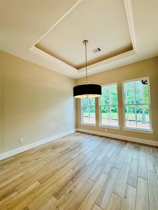 212 Rim Rock Rd, Huntsville, TX 77340 - spare room featuring a tray ceiling, light wood-type flooring, baseboards, and crown molding