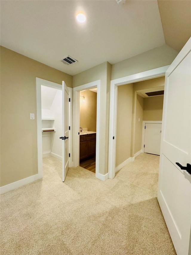 212 Rim Rock Rd, Huntsville, TX 77340 - unfurnished bedroom with light colored carpet, baseboards, a spacious closet, ensuite bath, and a closet