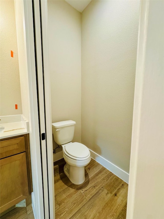 212 Rim Rock Rd, Huntsville, TX 77340 - bathroom with toilet, vanity, wood finished floors, and baseboards