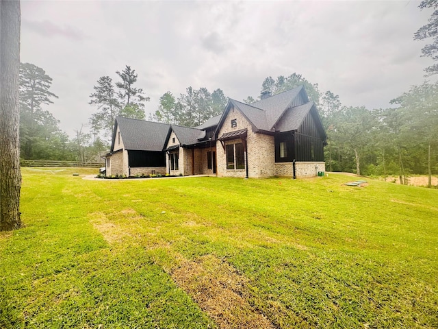 212 Rim Rock Rd, Huntsville, TX 77340 - rear view of house featuring a lawn and board and batten siding