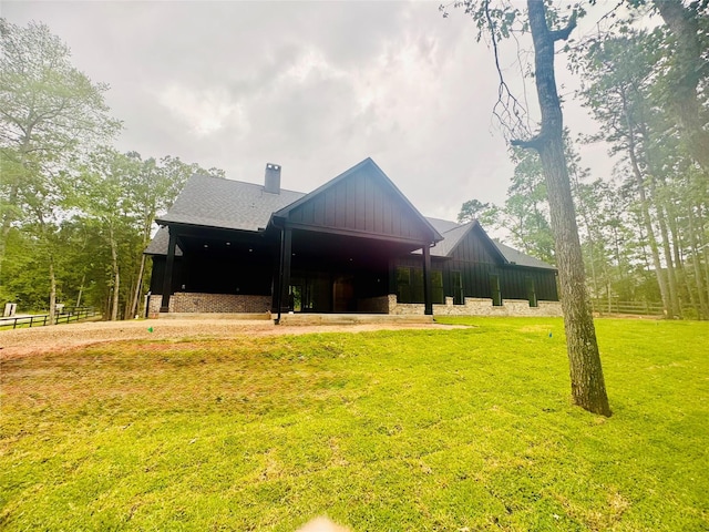 212 Rim Rock Rd, Huntsville, TX 77340 - back of house with a yard, a chimney, and board and batten siding