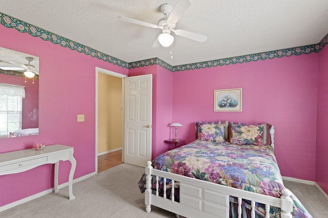 carpeted bedroom featuring a textured ceiling, a ceiling fan, and baseboards