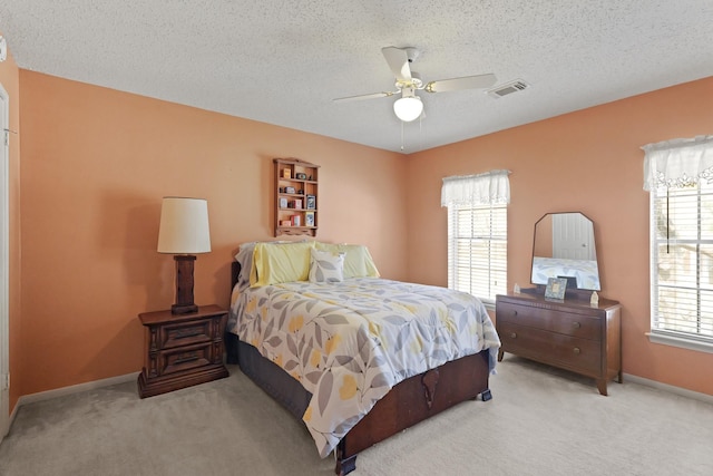 bedroom featuring visible vents, carpet flooring, ceiling fan, a textured ceiling, and baseboards