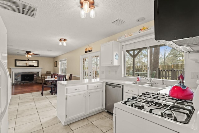 kitchen with a sink, a fireplace, visible vents, and dishwasher