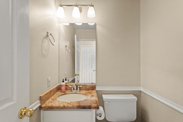 half bathroom with toilet and vanity