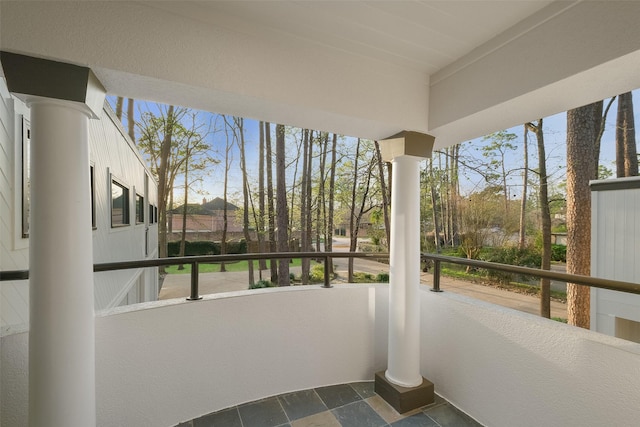 sunroom featuring decorative columns and a healthy amount of sunlight