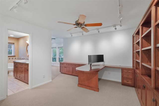 office featuring light colored carpet, a healthy amount of sunlight, ceiling fan, and rail lighting