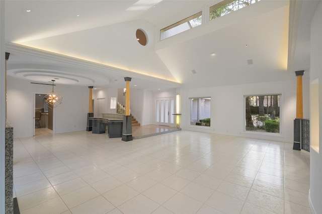 unfurnished living room featuring stairway, light tile patterned floors, and high vaulted ceiling