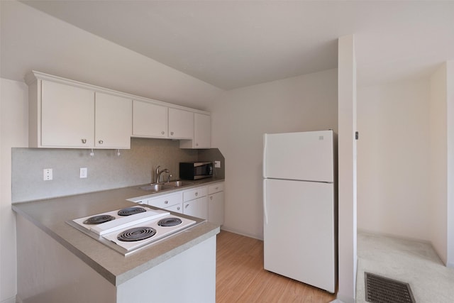 kitchen with visible vents, a sink, white cabinetry, white appliances, and a peninsula