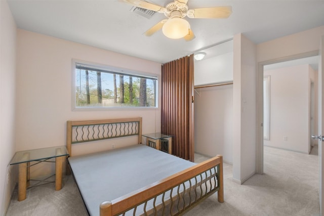 bedroom with a ceiling fan, visible vents, a closet, and light carpet