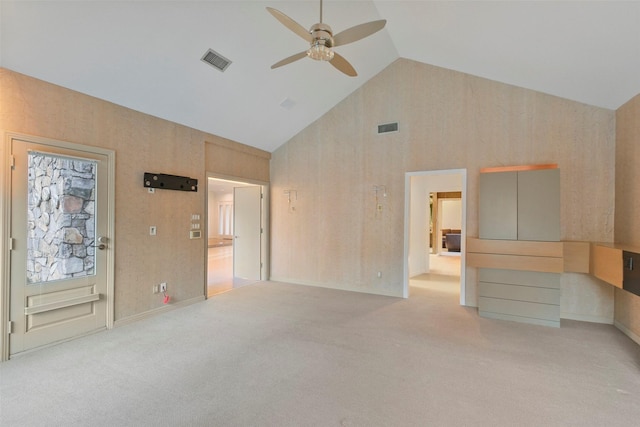 empty room with high vaulted ceiling, a ceiling fan, visible vents, and light carpet