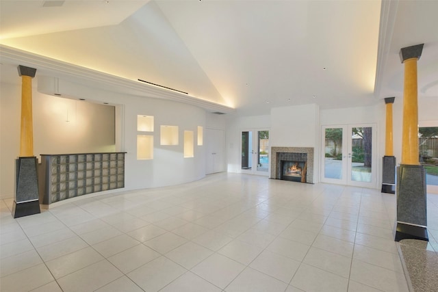 unfurnished living room with light tile patterned floors, french doors, high vaulted ceiling, and a wealth of natural light