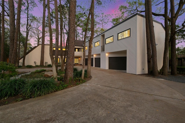 view of front facade featuring stucco siding, driveway, and an attached garage