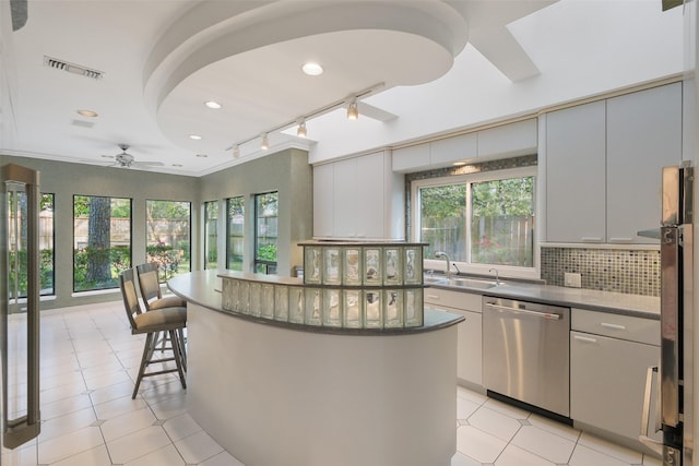 kitchen with a ceiling fan, visible vents, a sink, decorative backsplash, and dishwasher