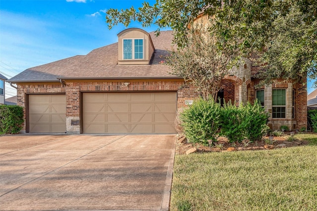 view of front of home featuring driveway, an attached garage, a shingled roof, and brick siding