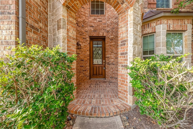 entrance to property featuring brick siding