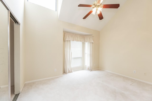 interior space with vaulted ceiling, baseboards, and light colored carpet