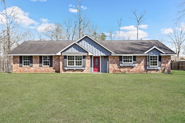 ranch-style home featuring board and batten siding, a front yard, brick siding, and a shingled roof