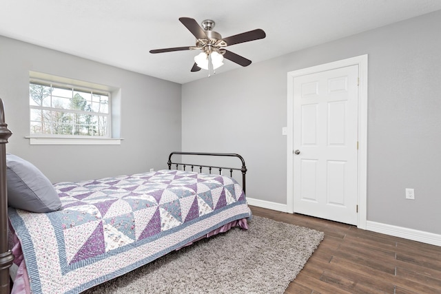 bedroom with a ceiling fan, baseboards, and wood finished floors